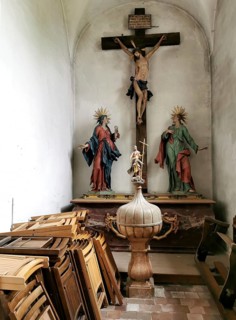 Side altar of the monastery church, also used as a storage room for chairs in front of the cross,
