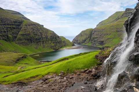 View of waterfall, meadows and fjord of Saksun, Streymoy Island, Faroe Islands, Denmark
