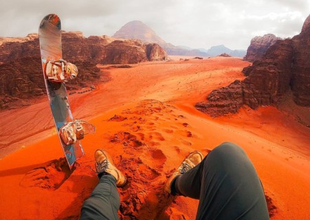 Rider pov Sand boarding from red dune Wadi Rum Jordan, traveler POV with board, desert adventure