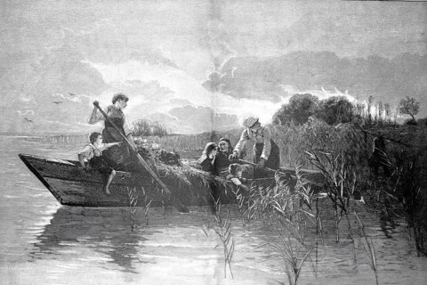 Young couple in folkloric traditional costume in a boat jokingly teased by passing fishermen or