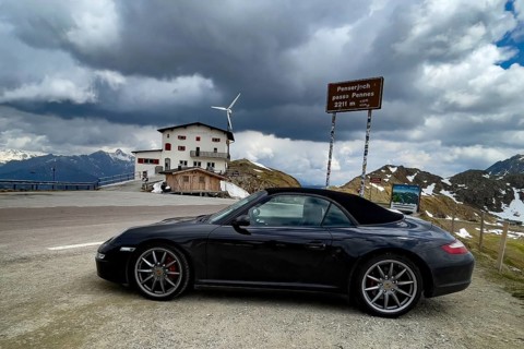 Porsche 911 Carrera 4s cabriolet 997 Convertible Car stands at pass height from mountain pass in