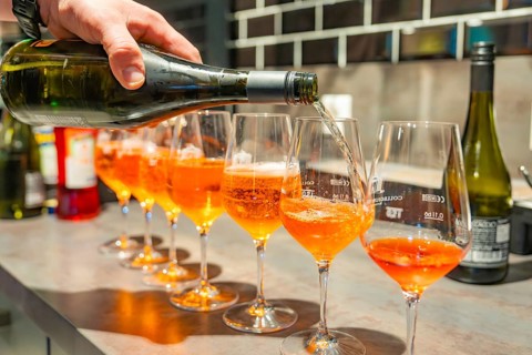 A drink is poured from a bottle into glasses with spritz at a modern bar, Cafe Kuh, Deckenpfronn,
