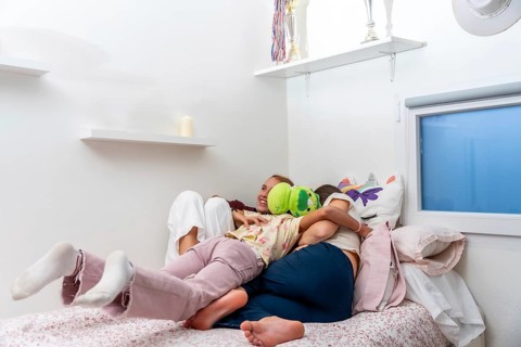 Family members, a mother and two children, are lovingly cuddling and enjoying playful moments