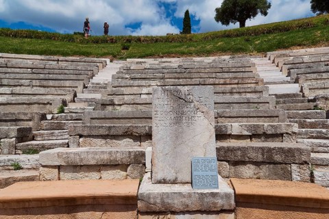 Ancient amphitheatre with rows of stone seats and an inscription panel, ancient site,