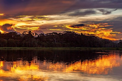 Sunset over a river with dramatic sky and intense reflections, sunset on the Beni River near