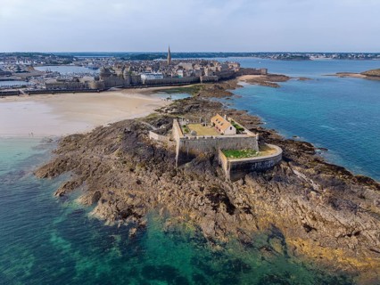 Aerial view of the historic Fort National island fort on the sandy beach of Saint Malo at low tide.