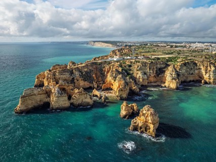 Aerial view of Ponte da Piedade in Lagos, Algarve, Portugal, with golden cliffs, ocean surf and sea