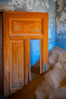 Interior view, door and house full of sand, former diamond mining town, Namib Desert, Kolmanskop,