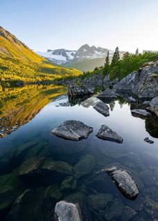 Picturesque mountain landscape in the Innerdalen high valley, mountain peaks reflected in Lake