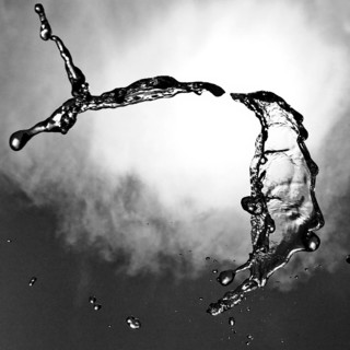 Water frozen as a result of short exposure moving in the backlight in front of the sky