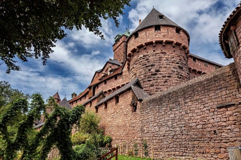 Historic castle with round towers and gardens under partly cloudy sky, The High King's Castle in