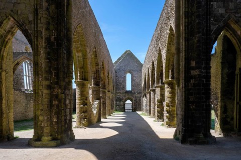 Perspective view of the medieval rows of pillars and pointed arches of the Gothic church ruins and