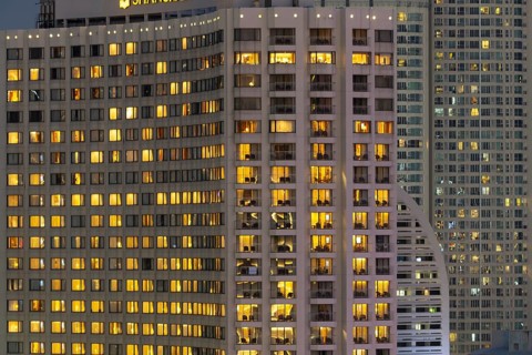Nocturnal view of the Shangri-La Hotel on the east bank of Chao Phraya, the warmly lit rooms stand