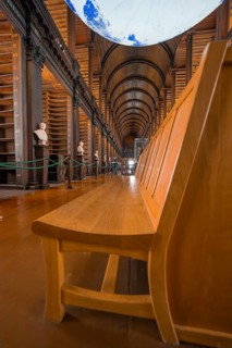 Wooden bench in a historic library with globe and classic busts, Trinity Collage, Dublin, Ireland