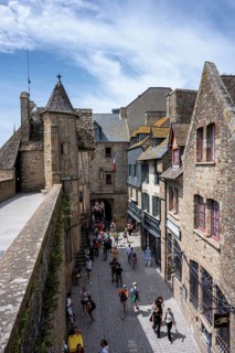 Tourists flock through a medieval alley surrounded by traditional stone houses within the fortress