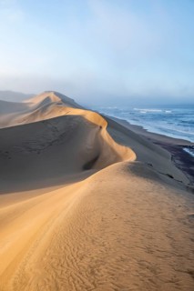 Sand dunes in morning light, view of Atlantic coast and sea, Sandwich Harbour, impressive desert