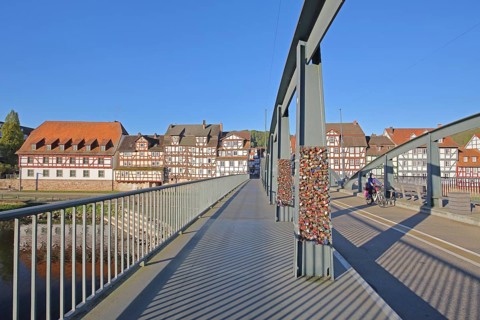 Old Fulda Bridge, bike path, steel girders with love locks, half-timbered houses on the banks of