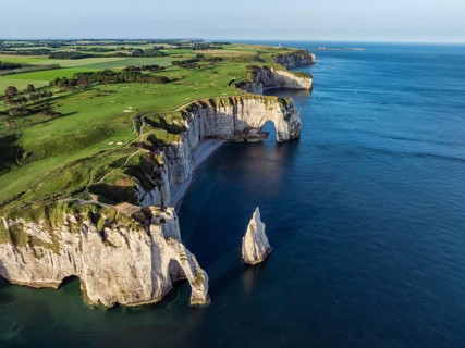 Aerial view of the Porte d'Aval rock formation with the free-standing Aiguille d'Étretat rock pin