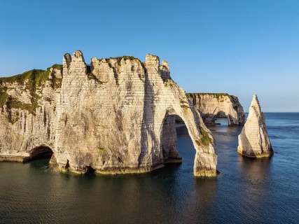 Aerial view of the Porte d'Aval rock formation with the free-standing Aiguille d'Étretat rock pin