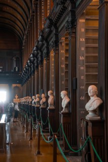 Row of busts along wooden pillars in a historic library, Trinity Collage, Dublin, Ireland