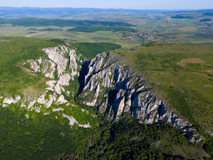 Aerial view of an impressive mountain range with distinctive limestone cliffs and green vegetation