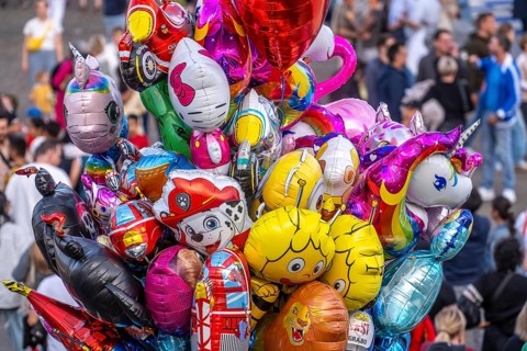 Many colorful motif balloons, filled with gas, float, with many different motifs, some comic