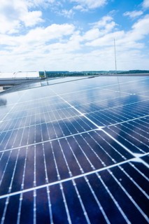 Solar modules on a roof against a blue, cloudy sky, PV installation, Perrot company, Calw, Germany