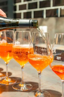 A drink is poured into a series of aperitif glasses with sparkling wine, Cafe Kuh, Deckenpfronn,