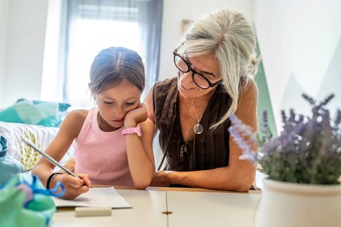 Grandmother and granddaughter bonding while doing homework together, fostering education, learning,