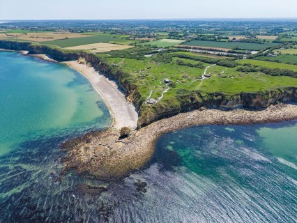 Aerial view of the historic Pointe du Hoc headland on the cliffs of Normandy. The green cliff rises