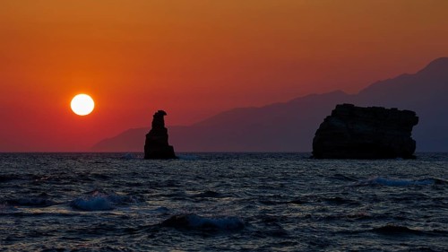 Atmospheric sunset over the sea with rocks and gentle waves, sunset, south of the Amari Basin,