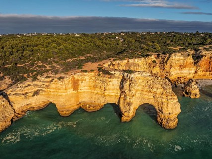 Aerial view of Praia da Marinha beach in Algarve, Portugal, with ocean cliffs, sea stacks and