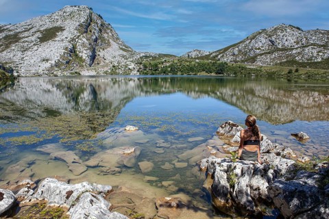 Middle aged woman contemplates the Enol lake, Covadonga lakes ensemble, Picos de Europa National