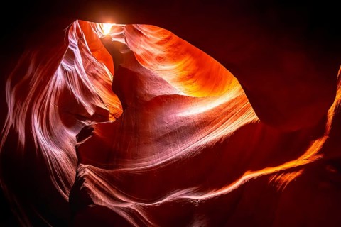 Antelope canyon's vibrant orange and red sandstone walls, sculpted by water and wind, creating a