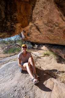 Tourist on a rock with prehistoric animal depictions, ancient rock carving of the San, indigenous