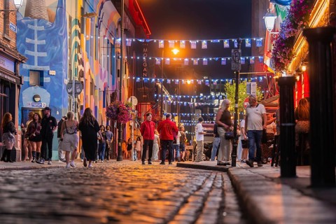 A busy street with people and festive lights in a lively atmosphere, nightlife, Dublin, Ireland