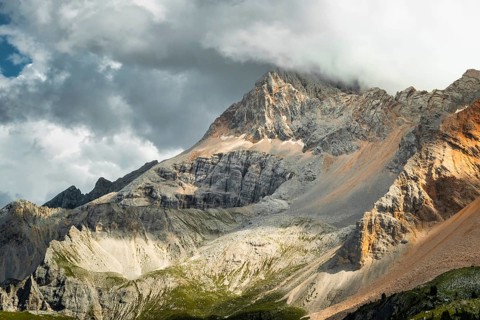 Dramatic mountain peaks colorful rocky scree slopes scenic alpine vista cloudy overcast sky