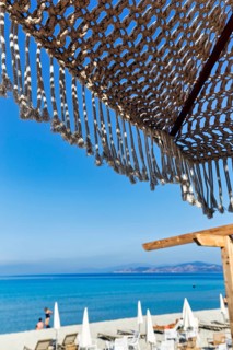 Macrame parasol with fringes, boho chic style, natural design, decoration, picturesque view from a