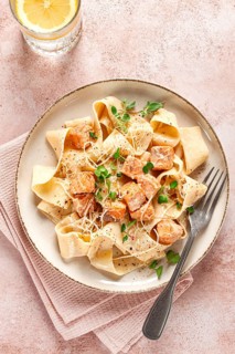 Tagliatelli pasta, with salmon slices and herbs, on a decorative plate, homemade, no people
