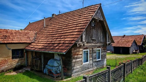 Old, traditional wooden house with adjacent barn and tiled roof, rural and rustic ambiance, Croatia
