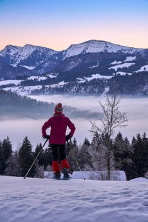 Sportive woman watching sunrise over the Nagelfluh mountain chain with Hochgrat summit in the