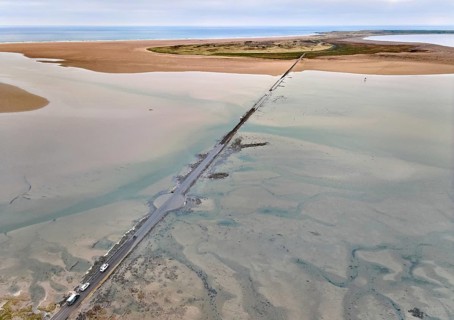 Aerial drone photograph of the causeway with floated road leading to Holy Island and Lindisfarne,