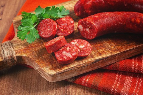 Spicy Chorizo sausage, on a cutting board, on a wooden table