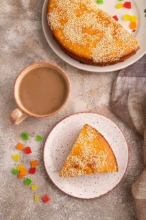 Pie with candied fruit, cup of coffee, on brown concrete background with linen beige textile, close