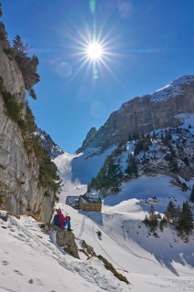 Woman hiking in the snowy mountain landscape of the Alpstein Säntis mountain range, Brülisau,