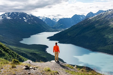 Mountaineer enjoys views of blue lake and mountains on Twin Peaks Trail, Eklutna Lake, Chugach