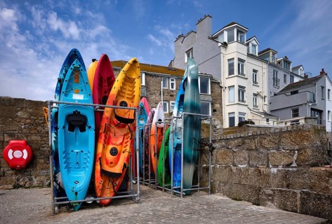 Colourful sea kayaks, sea kayaks, stand in the appropriate kayak stand, harbour, St Ives, Cornwall,