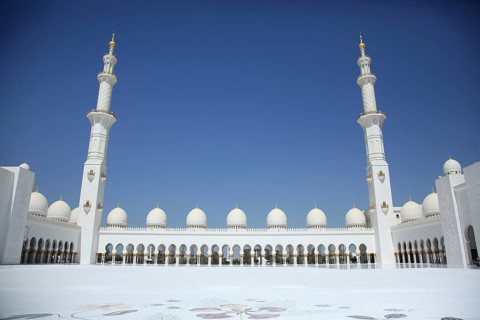 Mosque with long rows of columns and tall minarets against a clear sky, Sheik Zayed Mosque, Sheikh