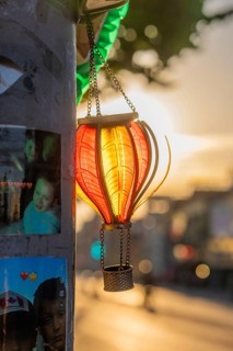 A lantern illuminated by the evening sun, next to photo stickers, Dublin, Ireland