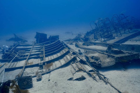 Underwater view of a shipwreck on the ocean floor with rusted metal structures, meteor wreck dive